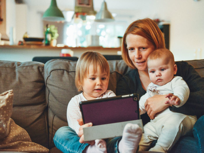 Woman and two children looking at a tablet screen