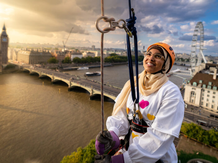 A person abseils against a sunset backdrop on the Thames.
