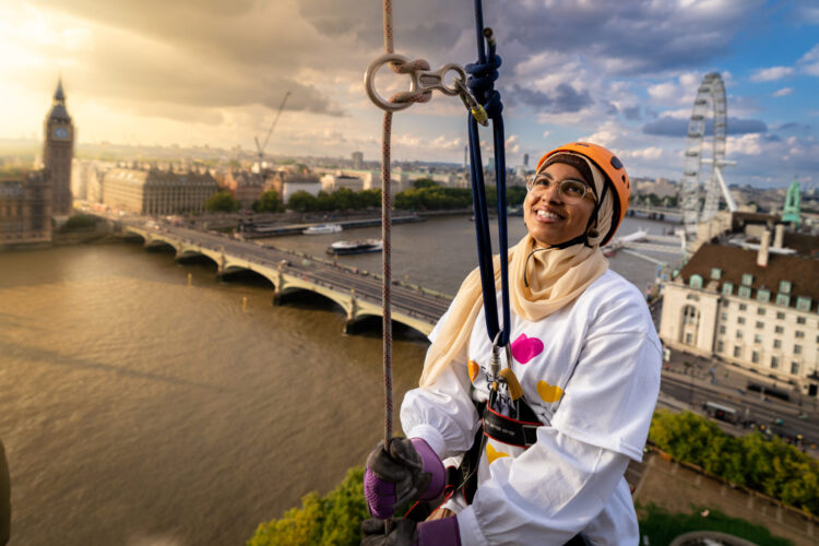 A person abseils against a sunset backdrop on the Thames.